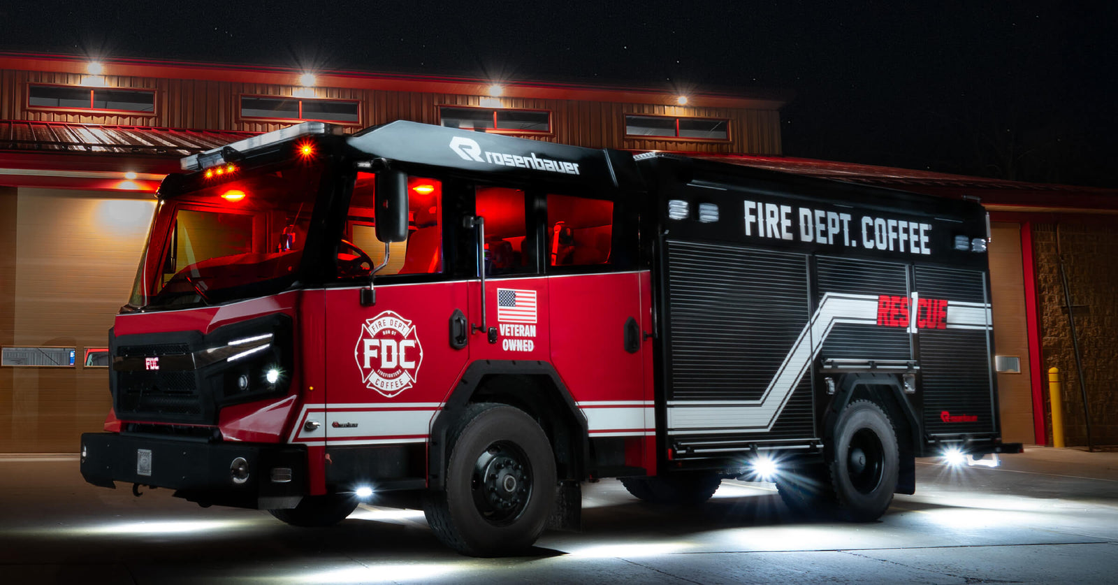 Fire truck in front of a fire station at night.