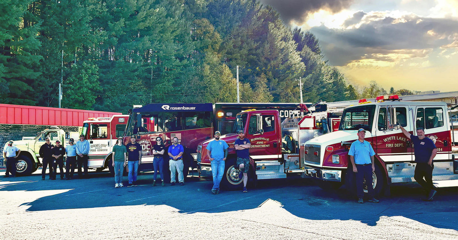 Group of people standing in front of fire and rescue trucks in Asheville, NC.