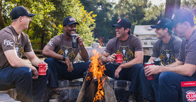 Orange County Firefighters sitting around a campfire drinking coffee.