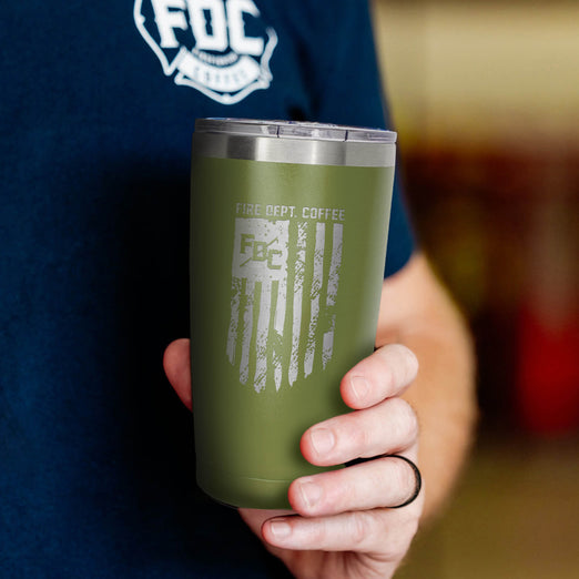 The front of the FDC Flag Green Tumbler 20oz in someones hands.