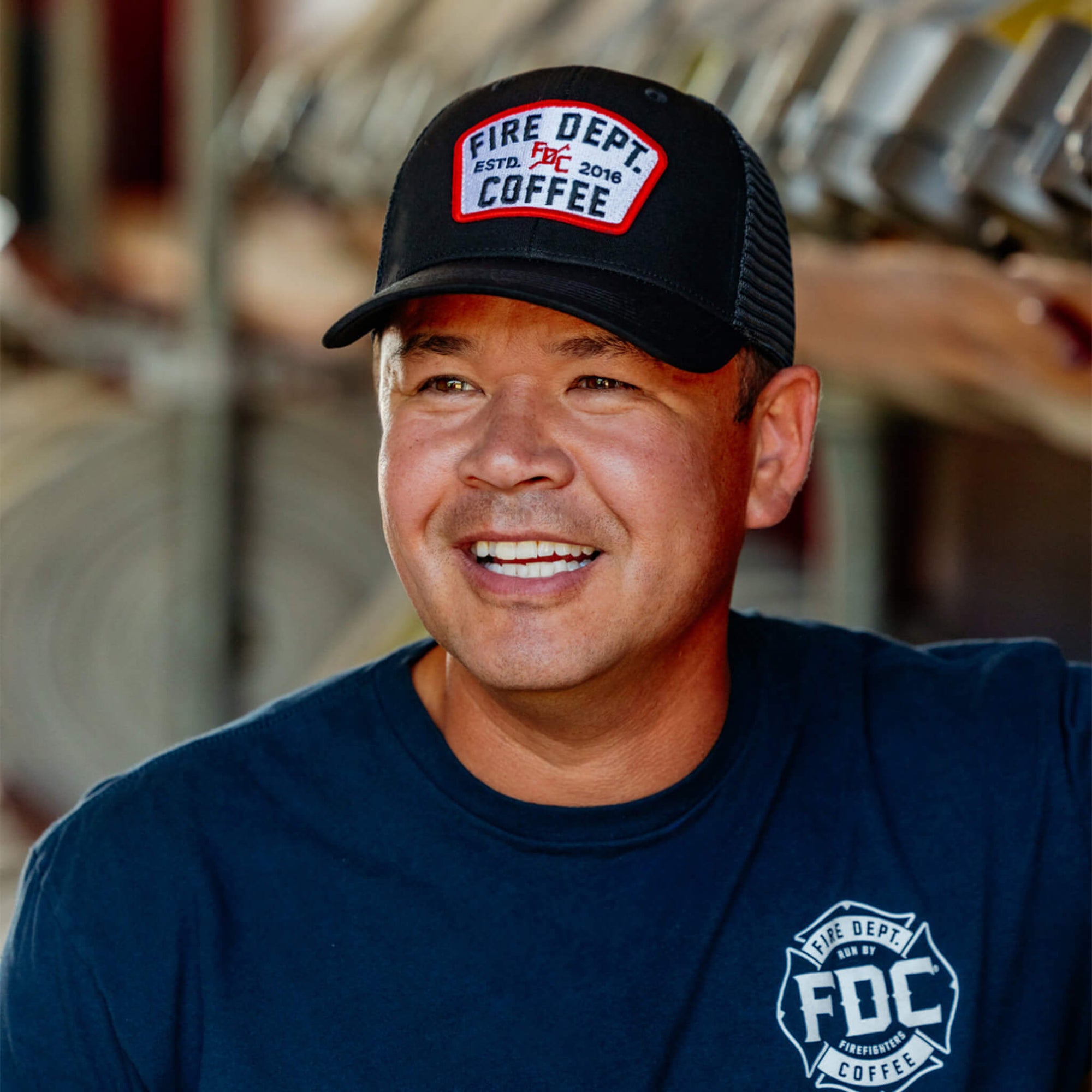 Black hat with black mesh back and a Fire Department Coffee keystone patch on the front