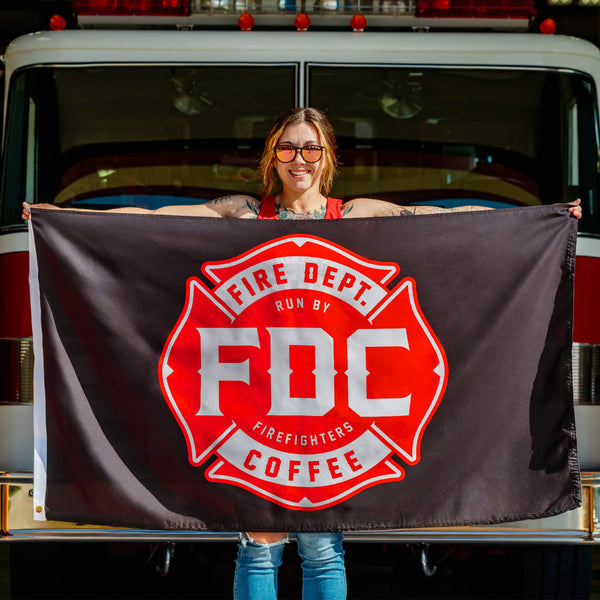 Black flag with a red FDC maltese cross logo in the center