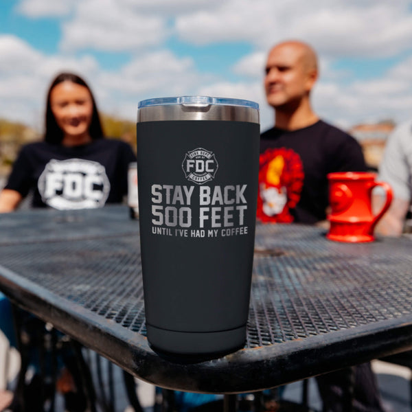 A 20 oz black tumbler that reads STAY BACK 500 FEET UNTIL I'VE HAD MY COFFEE