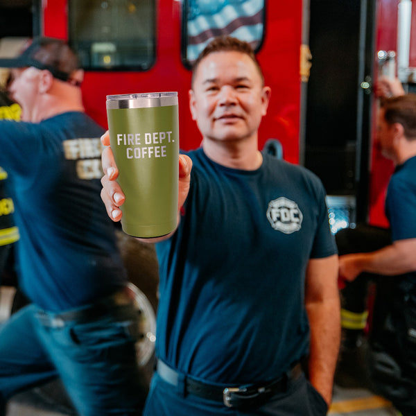 A 20 ounce green tumbler that has FIRE DEPT. COFFEE engraved on the front