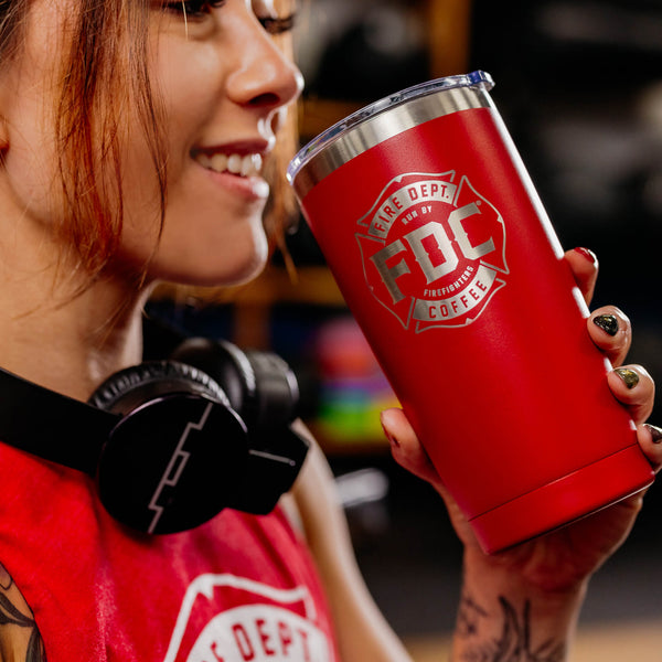 A 20 oz red tumbler with the FDC maltese cross logo engrave on the front.