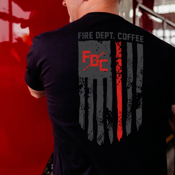 The back of a black t shirt with the thin red line going down the back. FDC pike pole logo is in the top right corner of the flag in red and text "fire dept. coffee" is above the flag.