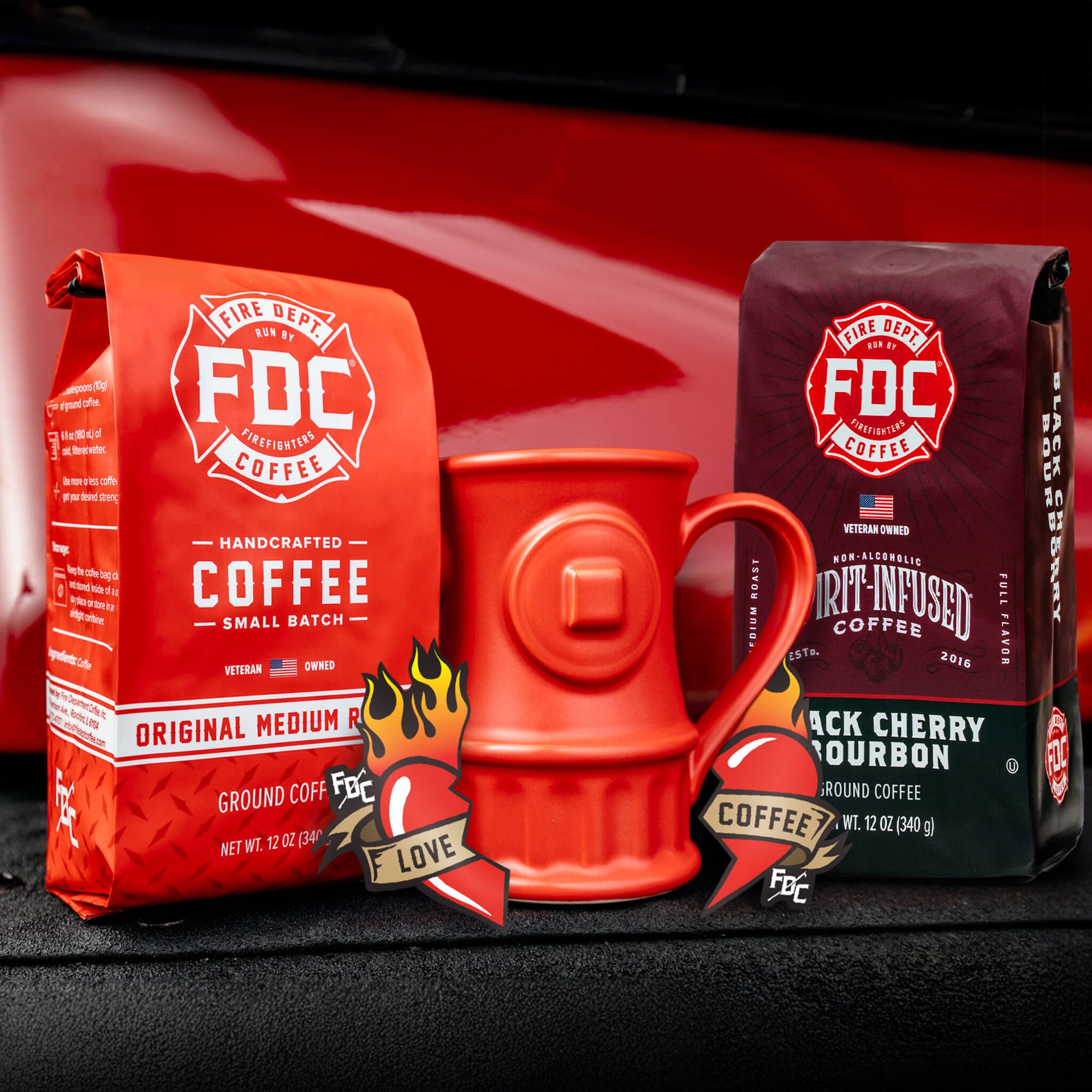 The Coffee Lovers Valentine's Day Bundle, containing a bag of Original Medium Roast, a bag of Black Cherry Bourbon Infused Coffee, a set of Love Coffee Stickers, and a Fire Hydrant mug.