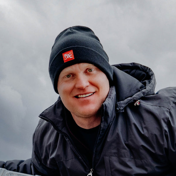 Fitted image of FDC black beanie with square red tag featuring a white FDC pike pole logo on the front of the hat