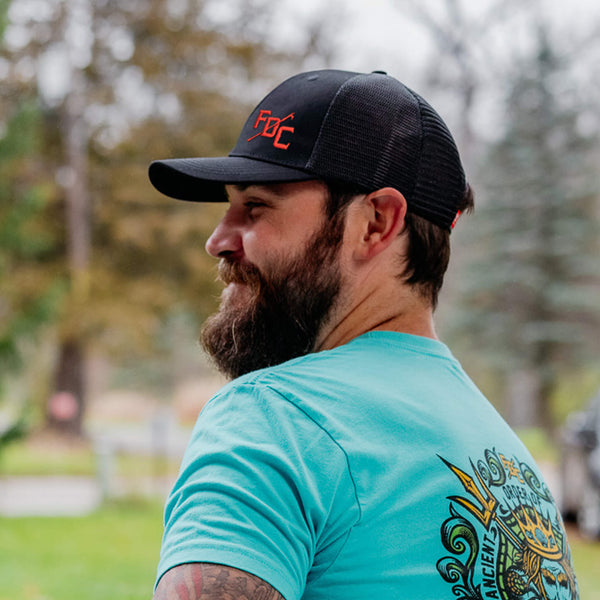 Side view of black hat with mesh back and a red FDC pike pole logo on the front