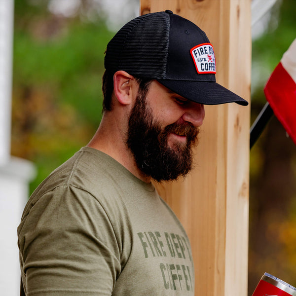 Black hat with black mesh back and a Fire Department Coffee keystone patch on the front