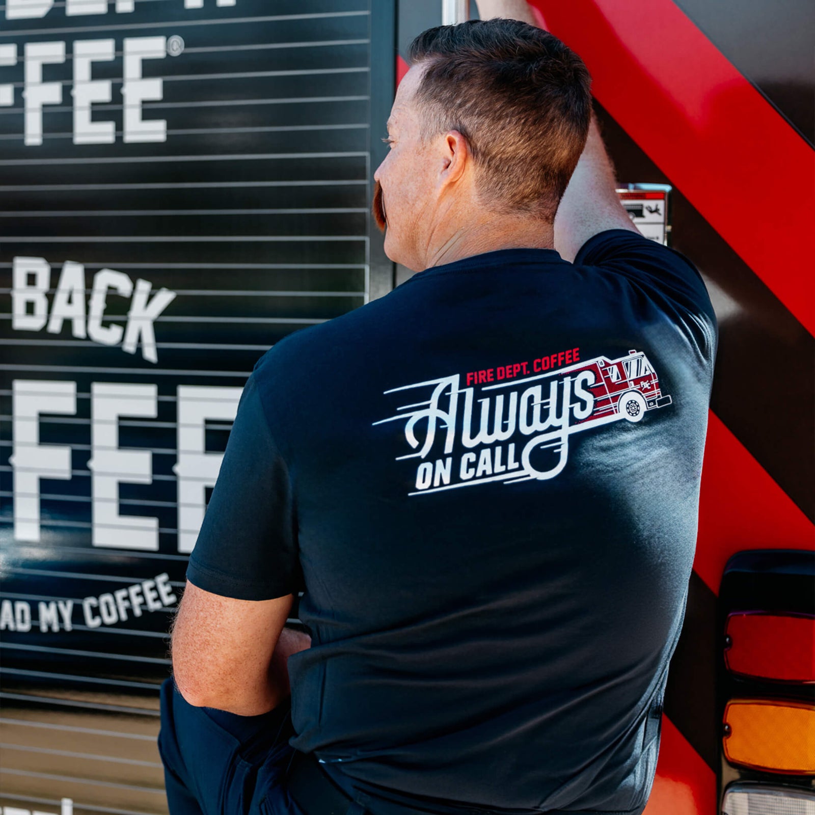 A shirt with an image of a fire truck rushing towards a job with the text "Fire Dept. Coffee Always On Call" written on it