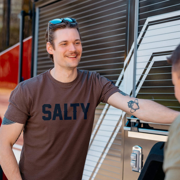 A heathered, espresso color t shirt with the text "Salty" across the chest in large, black letters.