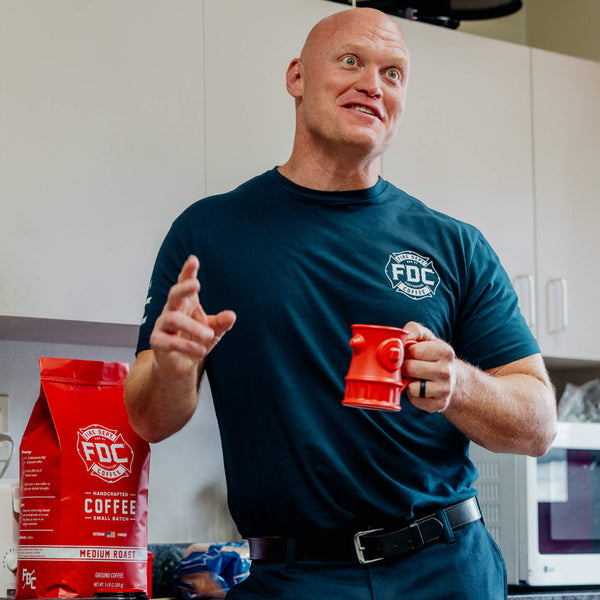 Back side of navy blue t shirt with large white lettering that reads "Stay back 500 feet until I've had my coffee" across the top