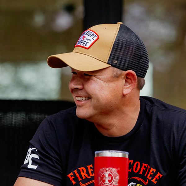 Tan hat with black mesh back and a Fire Department Coffee keystone patch on the front